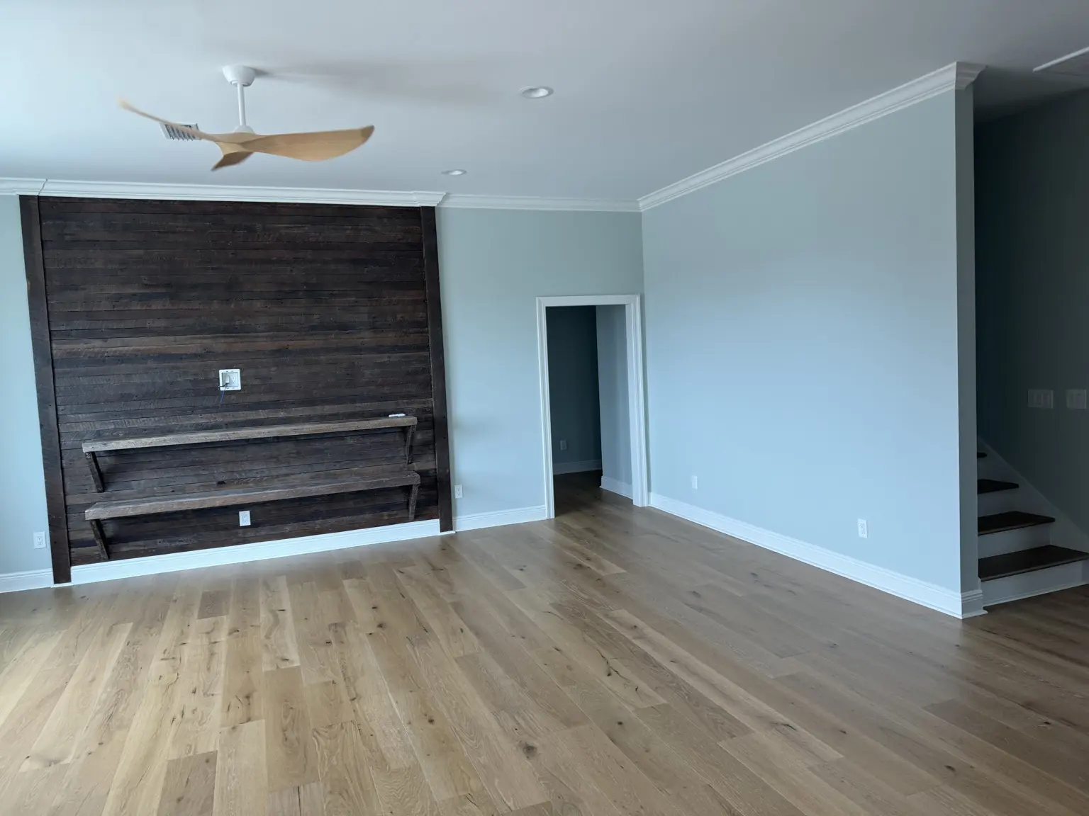 Completed room renovation with flooring and a wood feature wall