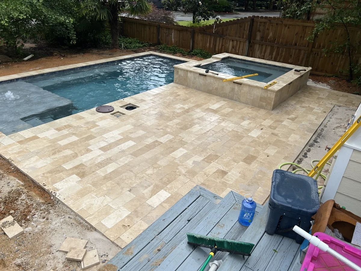 Pool and raised spa with tile, coping and deck paving during installation