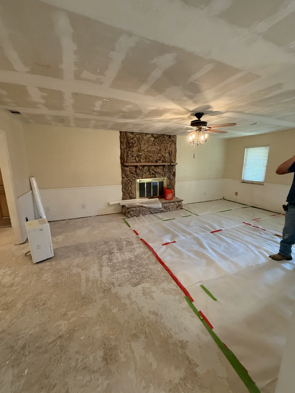 Patched living room ceiling and protected floor area